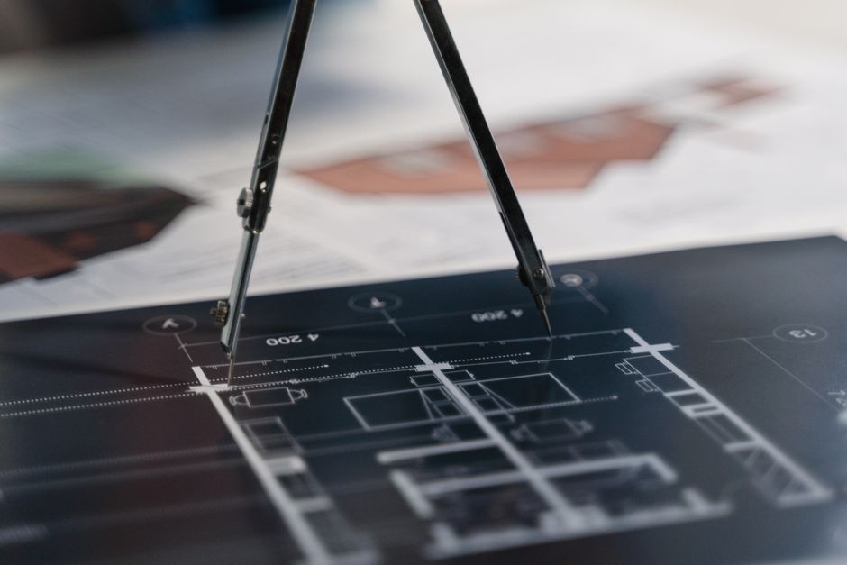 A detailed close-up shot of architectural blueprints rolled out on a table, with clean lines and annotations symbolizing foundational real estate knowledge.